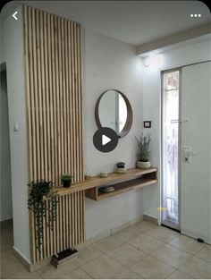 a room with a mirror, shelf and plant on it's wall next to a door