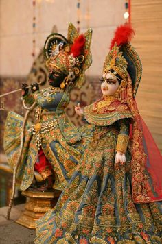 two dolls are dressed in colorful costumes