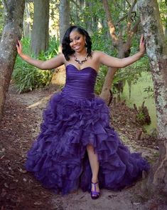 a woman in a purple dress posing for the camera