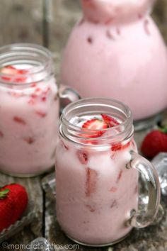 strawberry milkshake with whipped cream and fresh strawberries in the jar on wooden table