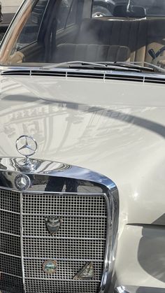 the front end of a white car with chrome grills