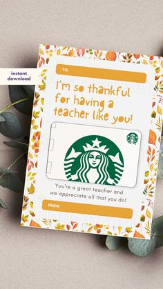 the starbucks gift card has been placed next to some leaves