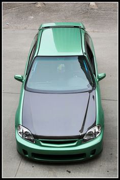 a green car is parked on the street