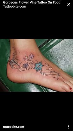 a foot tattoo with flowers and vines on it