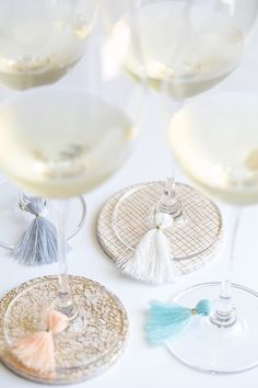 three wine glasses with tassels on them sitting next to each other