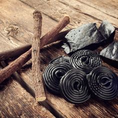 several pieces of metal sitting on top of a wooden table next to sticks and rocks