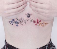 a woman's stomach with flowers and a bee on it