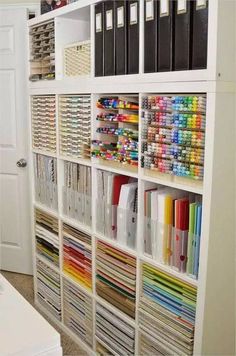 a white bookcase filled with lots of craft supplies