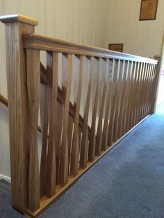 a wooden banister next to a blue carpeted floor