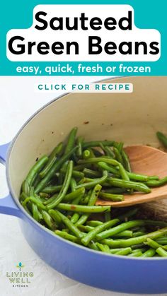 green beans are being cooked in a blue pot with a wooden spoon on the side