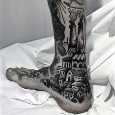 a man with a tattoo on his foot that has a castle in the middle and a clock tower at the top