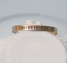 "CURRENT TURNAROUND TIME IS THREE (3) WEEKS ~Personalized Roman Numeral Cuff Bracelet - Special Date Bracelet - Engraved Custom Date Bracelet - Stacking Bracelet - Gift for Her '*.'*.'*.¸What You Will Receive ¸.*''.*''.*'' ❤ One (1) 1/4\" x 6\" brass cuff bracelet with brushed finish ❤ Items will be sent in clear cellophane bags. Boxes/gift packaging can be added at checkout for an additional fee. ❤ '*.'*.'*.¸What I Need To Complete Your Order ¸.*''.*''.*'' (enter the below info in the \"Note\" Gift Cuff Bangle With Stamped Detail, Gold Stamped Cuff Bracelet For Anniversary, Hand Stamped Bangle Bracelets For Anniversary, Adjustable Stamped Bangle For Anniversary, Adjustable Stackable Cuff Bracelet For Anniversary, Customizable Adjustable Vintage Jewelry, Adjustable Customizable Vintage Jewelry, Adjustable Bangle Cuff Bracelet For Anniversary, Adjustable Cuff Bracelet For Anniversary