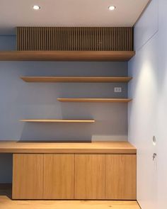 an empty room with wooden shelves and lighting