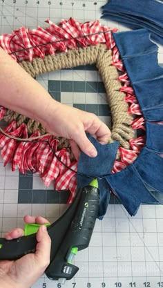 someone is making a wreath out of old jeans and burlocks with some scissors