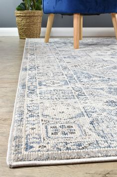 a blue couch sitting next to a rug on top of a wooden floor