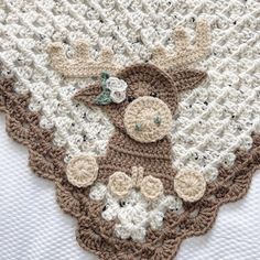 a crocheted blanket with a giraffe on it's face and flowers