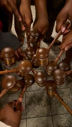 a group of people standing around each other with wooden mallets in front of them