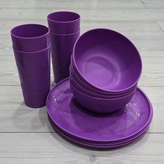 purple dishes and cups are arranged on the floor