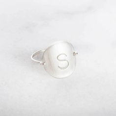 "Whatever you are, be all there." Simple and Sweet!  Our Initial Ring is a cute way to wear your initial or the initial of a loved one.   DETAILS Available ONLY in uppercase Block Font (as pictured).  Disc has a brushed matte finish.  Disc size is 5/8 inch which is comparable to a dime. NOTE All JM products are artisa Block Font, Pvd Coating, Emerald Earrings Studs, Initial Earrings, Organic Jewelry, Bar Ring, Name Rings, Hammered Rings, Silver Stacking Rings