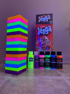 a stack of neon colored building blocks next to an unopened box of paint