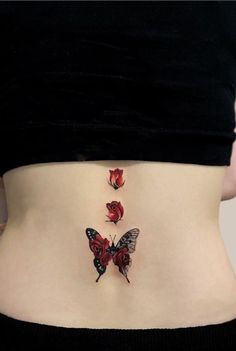 a woman's stomach with three butterflies on the side, and one is red