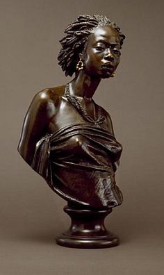 a bronze statue of a woman with braids on her head