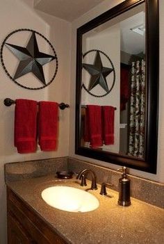 an image of a bathroom with red towels on the counter and star decorations above it