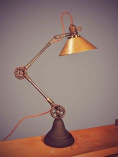 an antique desk lamp on top of a wooden table