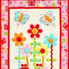 a quilted wall hanging with flowers and bugs on it's side, in pink