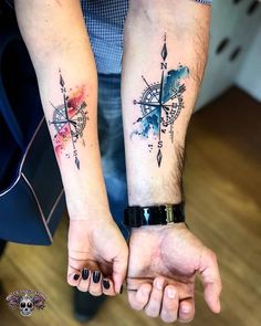 two people are holding hands with tattoos on their arms and one is holding the other hand