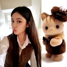 a girl with long brown hair and a stuffed animal in front of her is looking at the camera