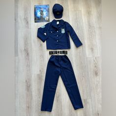 a police officer uniform is laying on the floor next to a dvd case and hat