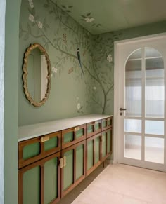 a bathroom with green walls and floral wallpaper on the walls, along with wooden cabinets