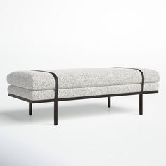 a white couch sitting on top of a wooden frame next to a black metal leg