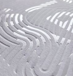 a close up view of an intricate design on a piece of paper with white paint