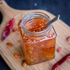 a jar filled with food sitting on top of a wooden cutting board