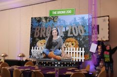 a woman sitting on top of a table next to a sign that says bronx zoo