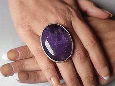 Crafted with precision and care, this handmade adjustable amethyst ring is a captivating piece of womens jewellery that captures the essence of elegance and individuality. The striking oval amethyst, the February birthstone, takes centre stage in this adjustable ring, its deep purple hue symbolising tranquillity and inner strength. The large, bold setting of this ring makes it an unusual and eye-catching choice, perfect for those who seek to make a statement with their accessories. Whether worn Adjustable Formal Crystal Ring With Gemstone, Formal Adjustable Gemstone Crystal Ring, Adjustable Gemstone Crystal Ring For Formal Occasions, Adjustable Amethyst Ring With Natural Stones, Amethyst Crystal Ring With Natural Stones, Oval Crystal Ring For Jewelry Making, Adjustable Purple Amethyst Ring With Stone Setting, Adjustable Amethyst Crystal Ring With Natural Stones, Adjustable Amethyst Jewelry With Large Stone