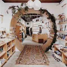 a store with lots of wooden shelves and plants on the wall, along with an area rug