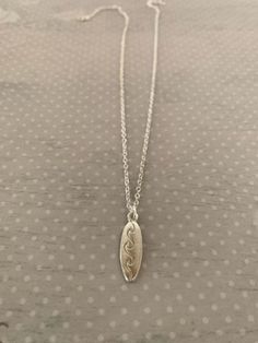 "Dainty silver tone surfboard necklace with engraved wave design, surfboard necklace, surfboard jewelry, surfboard pendant, surf board necklace, surfer necklace, surfer gifts Pendant measures 7/8\" L X 1/4\" W and is on an 18\" chain. ★ Want to see more?  Please visit my shop at: https://www.etsy.com/shop/DesignsByPeg" Surfboard Jewelry, Surf Necklace Men, Surf Board Necklace, Surfer Necklaces, Surfer Gifts, Surfing Jewelry, Surfboard Necklace, Men’s Surfer Necklace, Surf Yoga