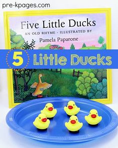 five little ducks sitting on top of a blue plate with a book in the background