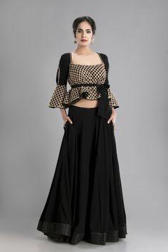 For all who love the glamour that black lends to our look, this skirt created from the flowing crepe epitomizes easy draping suited as much to formal wear as to that chic all-girl evening out. he gold embellished top with cutaway cold shoulders and the fanning our sleeves, make the effect all the cooler, despite the sultriness of black and gold. Invoke the glamour and glitz for the party-swing into the party mood as the gold and the gorgeous feel of soft black crepe flows around creating the mos Indian Kurti Designs, Choli Dress, Kurti Sleeves Design, Choli Blouse, Lehnga Dress, Indian Gowns Dresses