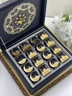 a box filled with lots of gold and black magnets on top of a table