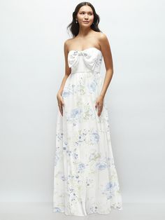 a woman wearing a white dress with blue flowers on it