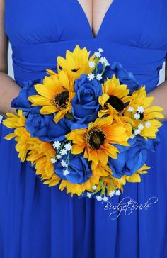 a woman in a blue dress holding a bouquet of sunflowers