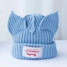 a blue hat with a bow on the front and label that says loveboy written on it