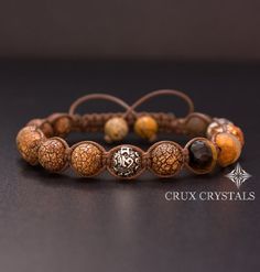 the bracelet is made with brown beads and silver clasps, which are decorated with an intricate