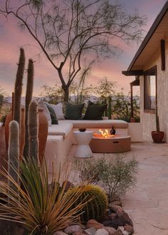 a fire pit in the middle of a patio surrounded by cactus and cacti