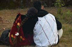 two women sitting on the ground with their backs to each other