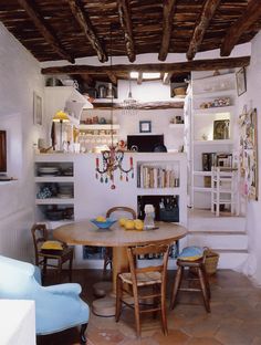 a table and chairs in a room with exposed wood beams on the ceiling above it